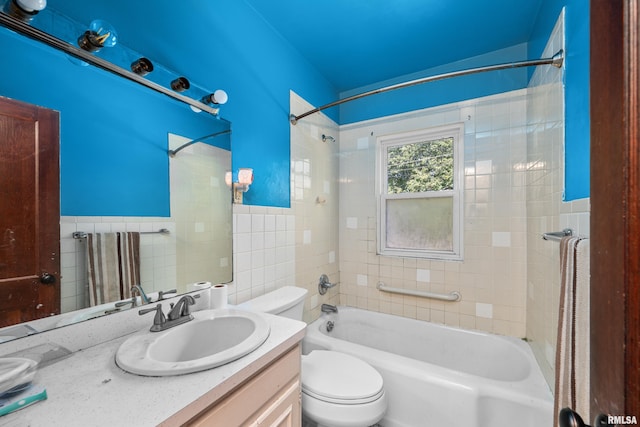 full bathroom featuring vanity, toilet, tile walls, and tiled shower / bath combo