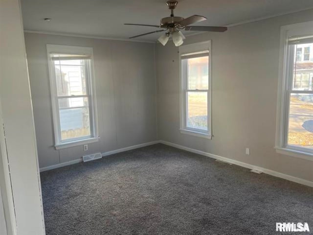 unfurnished room featuring ceiling fan, dark carpet, and crown molding