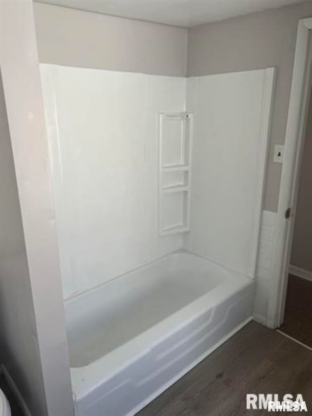 bathroom with wood-type flooring and  shower combination