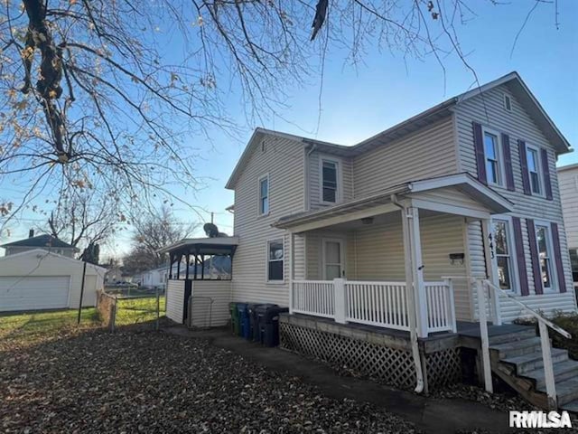 view of side of property featuring an outbuilding, a porch, and a garage