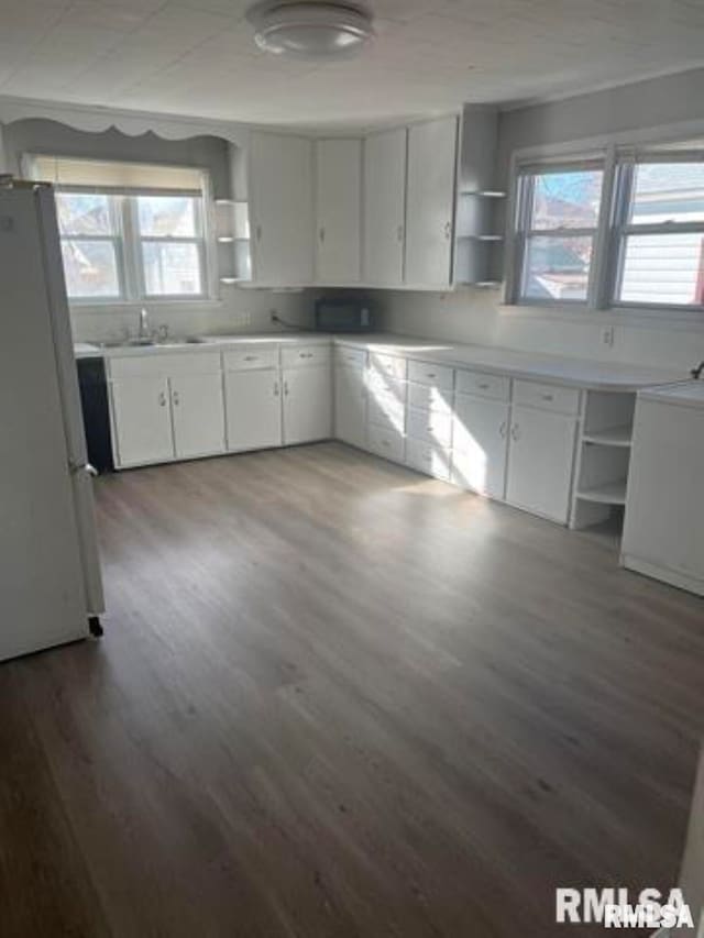 kitchen with white cabinets, white refrigerator, dark hardwood / wood-style flooring, and sink