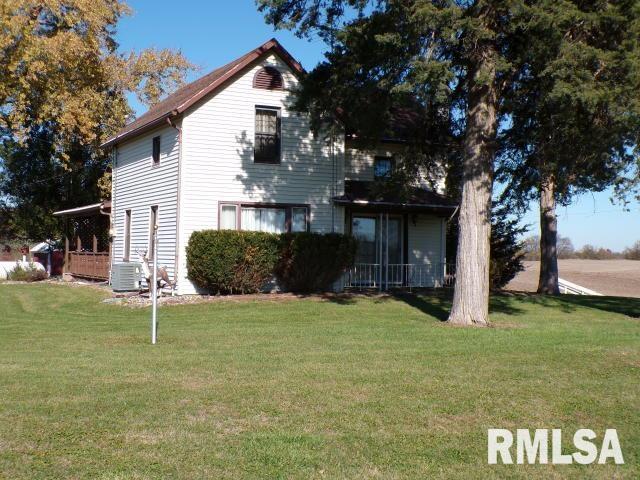 rear view of property featuring central air condition unit and a lawn