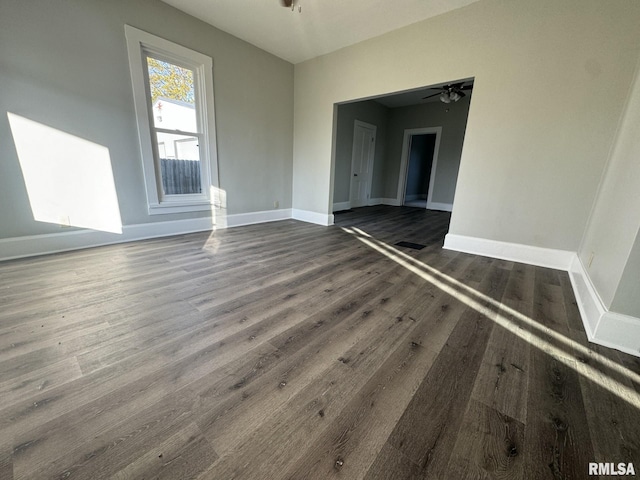 empty room featuring dark wood-type flooring and ceiling fan