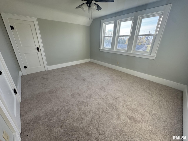 carpeted spare room featuring lofted ceiling and ceiling fan