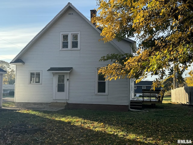 rear view of property featuring a yard and a wooden deck