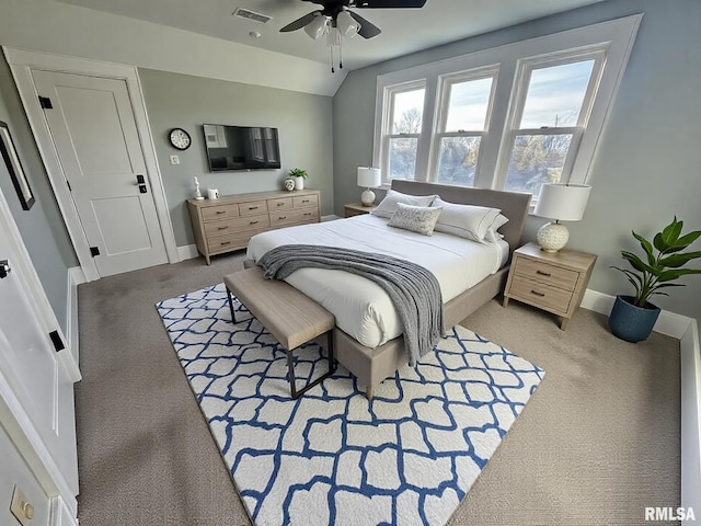 bedroom with baseboards, visible vents, a ceiling fan, vaulted ceiling, and carpet floors