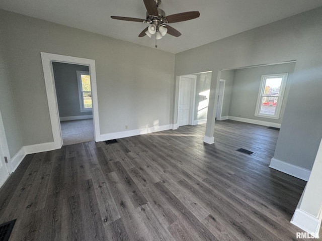 interior space with ceiling fan, a wealth of natural light, and dark hardwood / wood-style floors