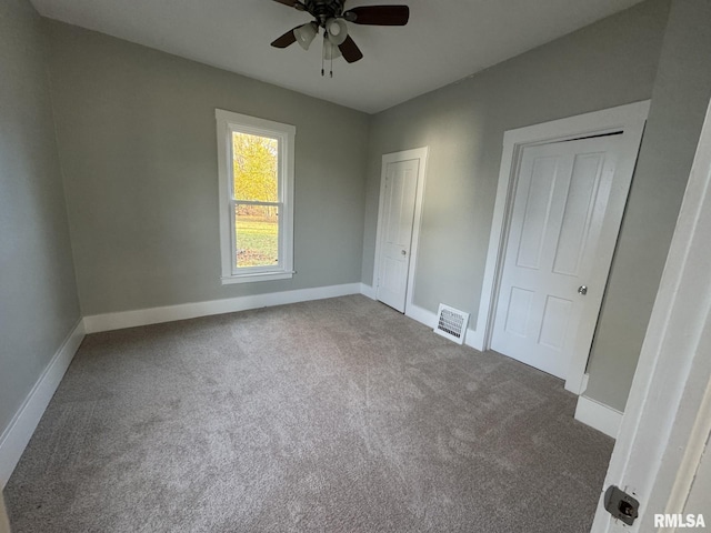 unfurnished bedroom featuring dark carpet and ceiling fan