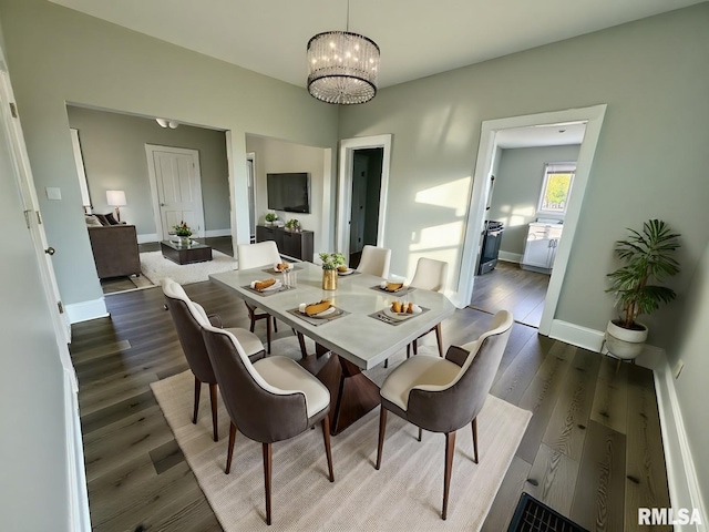 dining space featuring an inviting chandelier, baseboards, and wood finished floors