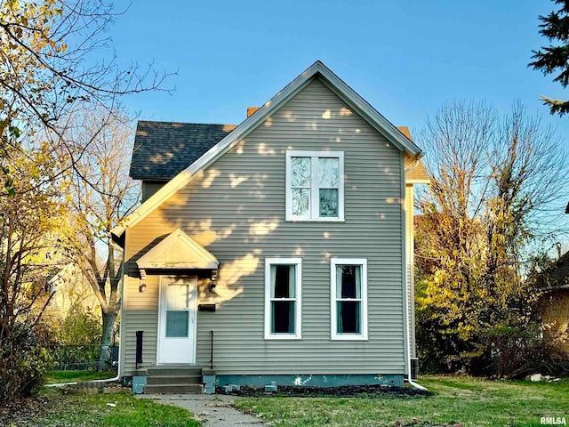 rear view of property with a yard