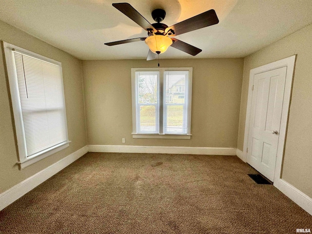 unfurnished room featuring ceiling fan and carpet floors