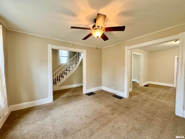 carpeted empty room with ceiling fan and ornamental molding