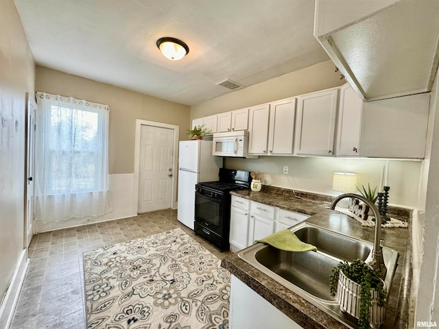 kitchen with white cabinets, white appliances, and sink