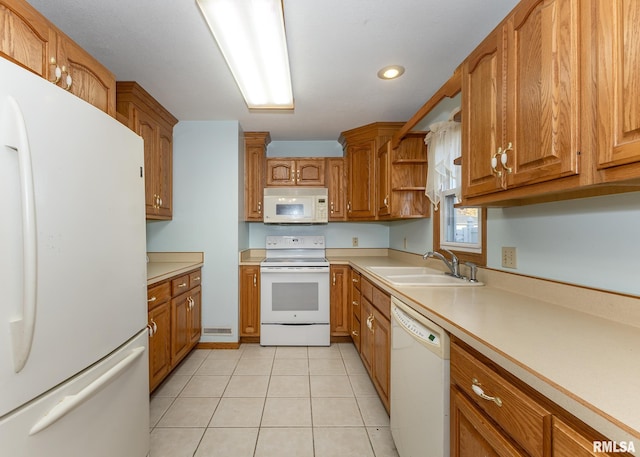 kitchen featuring sink, white appliances, and light tile patterned floors