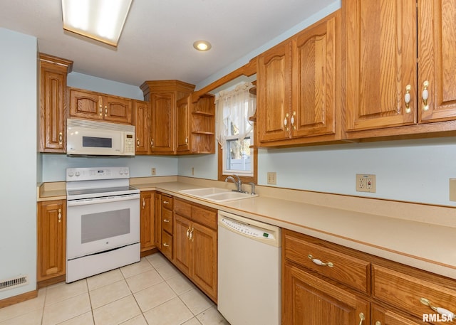 kitchen featuring white appliances, sink, and light tile patterned floors