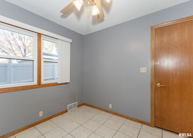 tiled spare room with ceiling fan