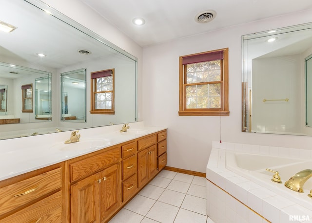 bathroom with vanity, tile patterned floors, a healthy amount of sunlight, and tiled tub