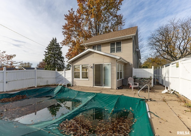 rear view of house with a covered pool and a patio area