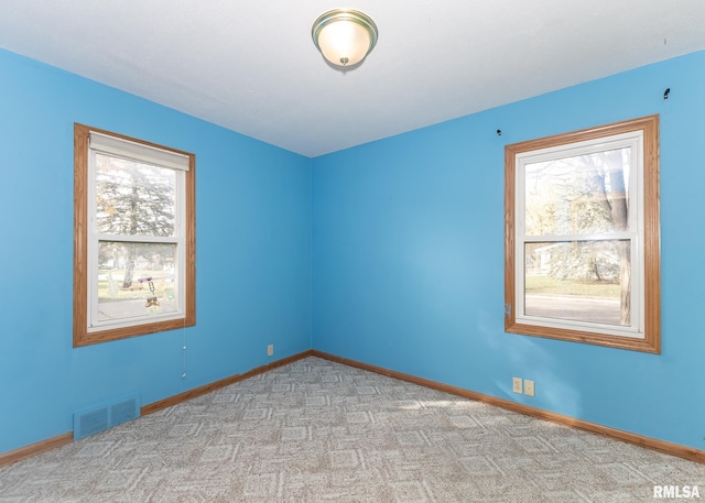 unfurnished room featuring plenty of natural light and light colored carpet