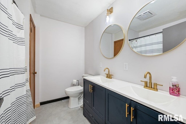 bathroom featuring tile patterned flooring, vanity, and toilet