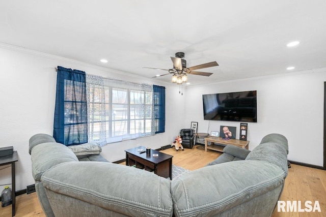 living room featuring ornamental molding, light hardwood / wood-style floors, and ceiling fan