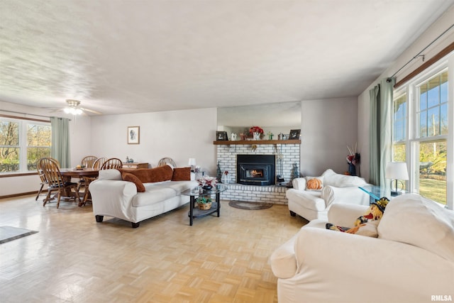 living room with light parquet flooring, a wood stove, and ceiling fan