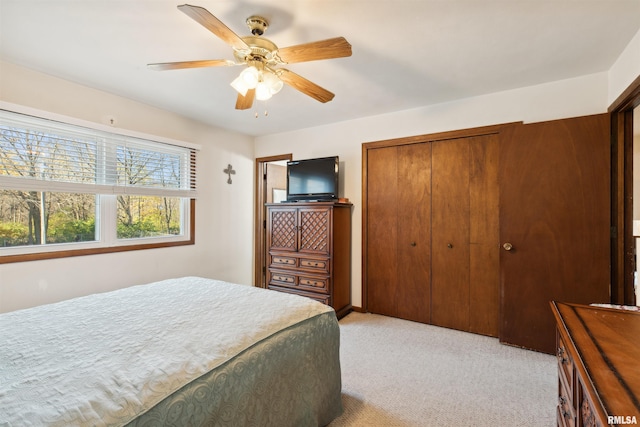 carpeted bedroom featuring a closet and ceiling fan