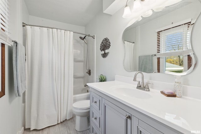 full bathroom with hardwood / wood-style floors, vanity, toilet, and shower / bath combo