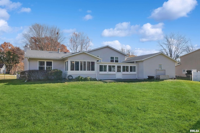 back of property with a sunroom and a yard