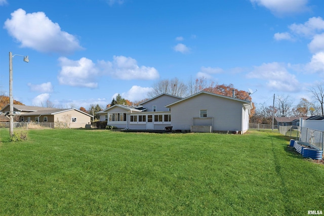 rear view of property featuring a lawn