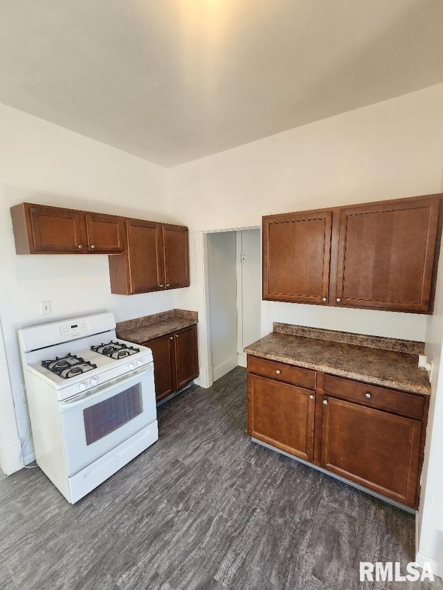 kitchen featuring dark wood-type flooring and white gas range