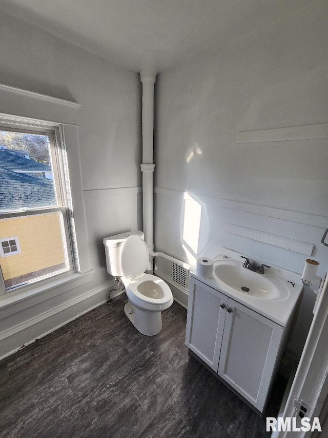 bathroom with hardwood / wood-style flooring, vanity, and toilet