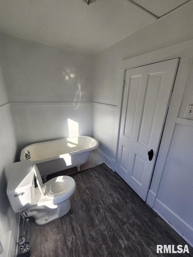 bathroom featuring a bathtub, toilet, and wood-type flooring