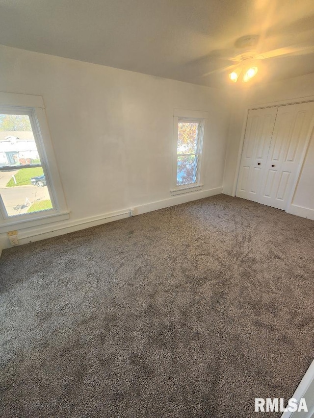 unfurnished bedroom with carpet flooring, ceiling fan, and a closet