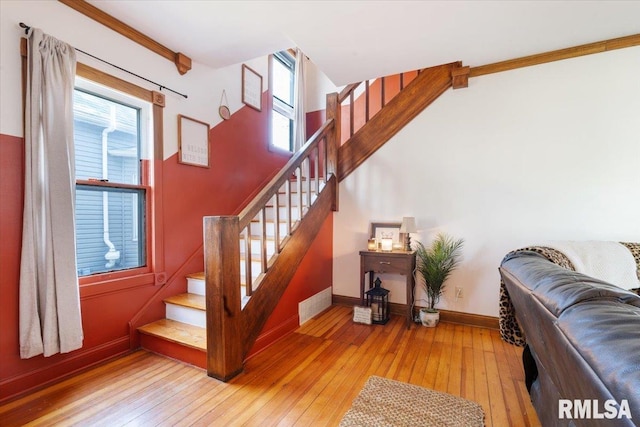 staircase featuring hardwood / wood-style flooring and crown molding