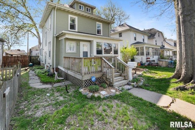 view of front facade with a front lawn and a wooden deck