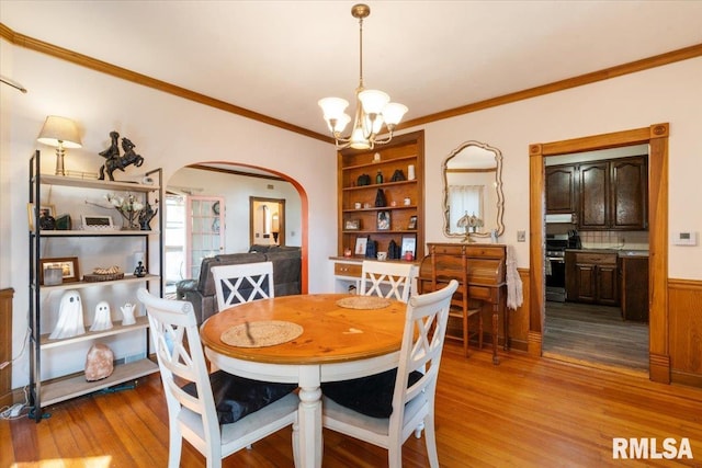 dining room featuring ornamental molding, an inviting chandelier, and light hardwood / wood-style floors