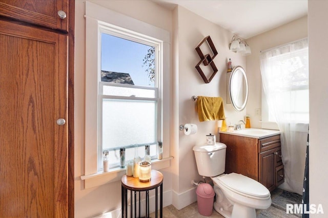 bathroom with vanity, tile patterned flooring, plenty of natural light, and toilet