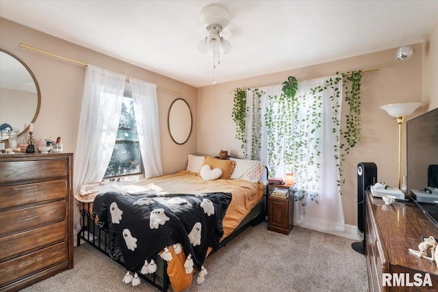 bedroom with ceiling fan and light carpet