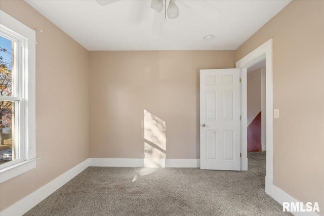 carpeted empty room featuring ceiling fan