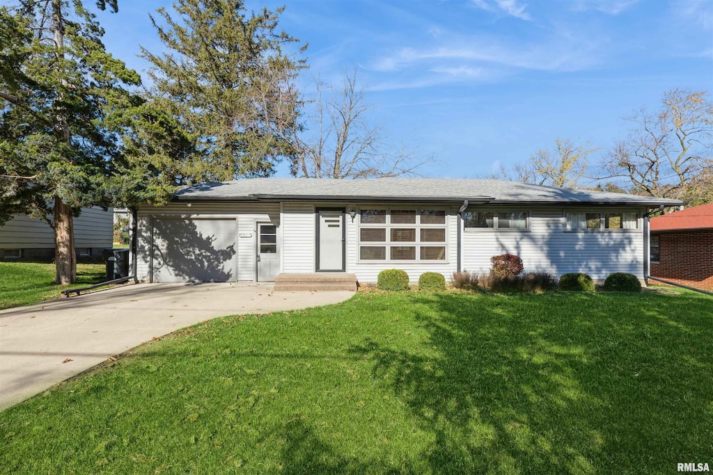 ranch-style home featuring a garage and a front lawn