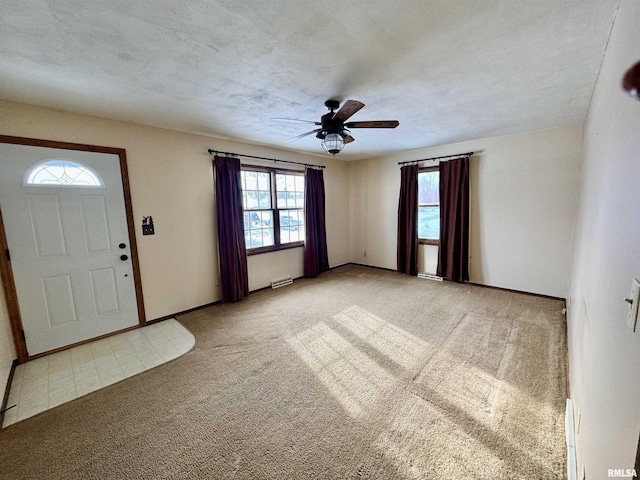 carpeted entryway featuring a textured ceiling and ceiling fan