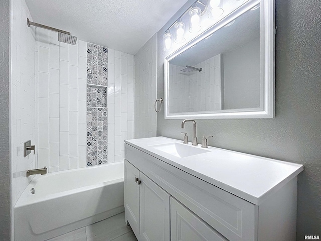 bathroom with vanity, a textured ceiling, and tiled shower / bath combo