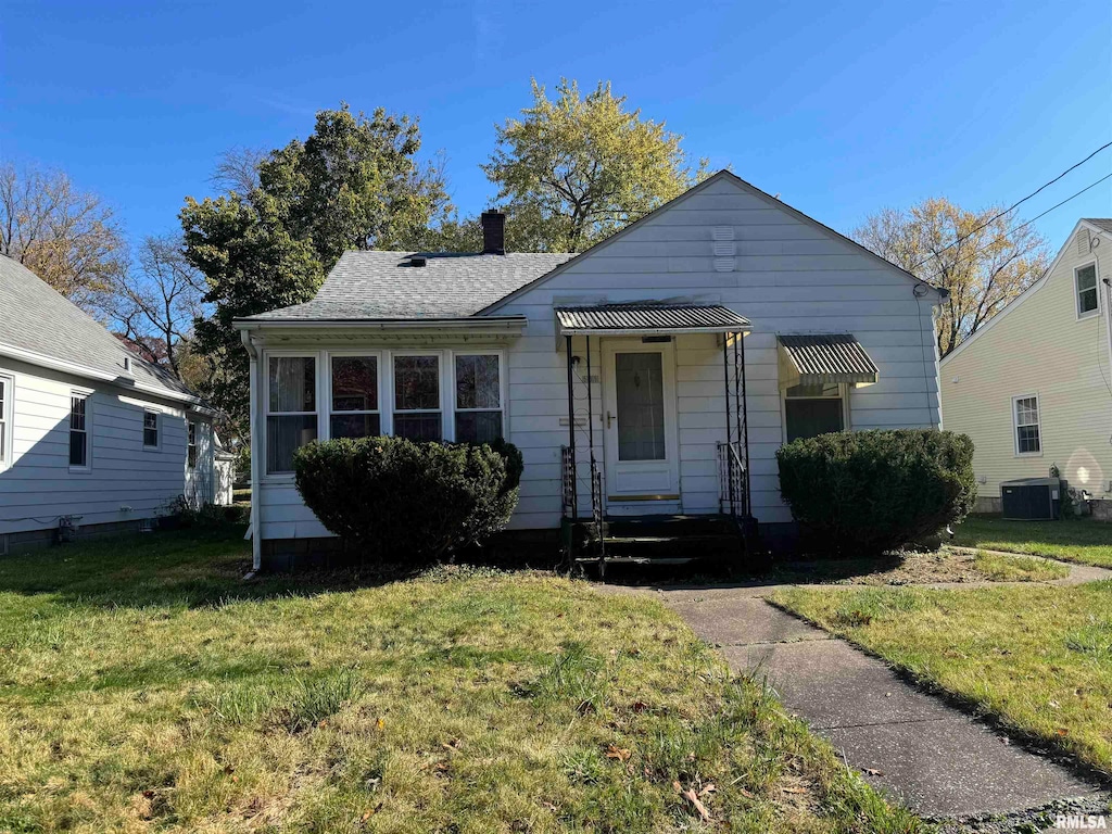 bungalow-style house with central AC and a front yard