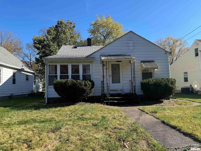 bungalow-style house with central AC and a front yard