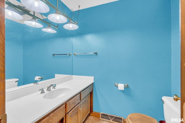 bathroom with tile patterned flooring, vanity, a textured ceiling, and toilet