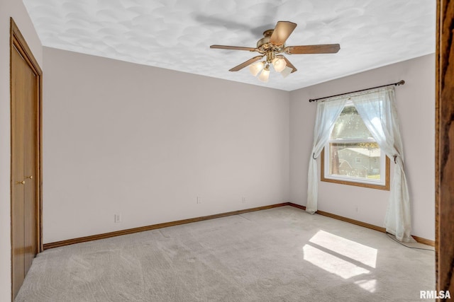 unfurnished bedroom with light colored carpet and ceiling fan