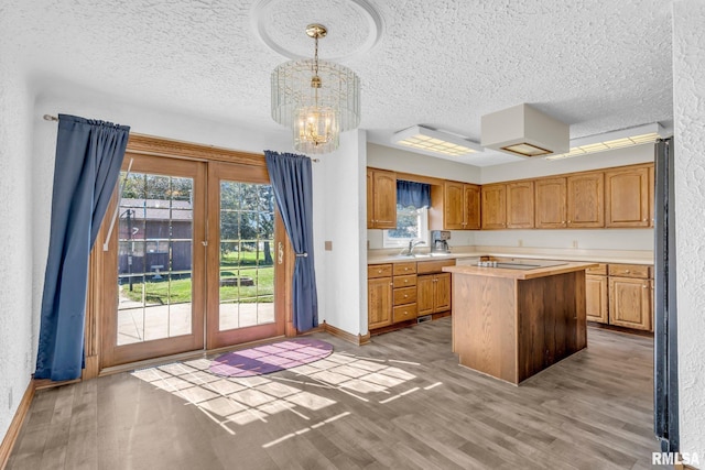 107 Hilltop St, Colona, IL 61241 - kitchen with light countertops, french doors, light wood-style floors, a chandelier, and a textured ceiling