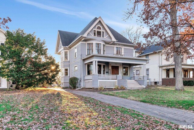 victorian home with a front yard and covered porch