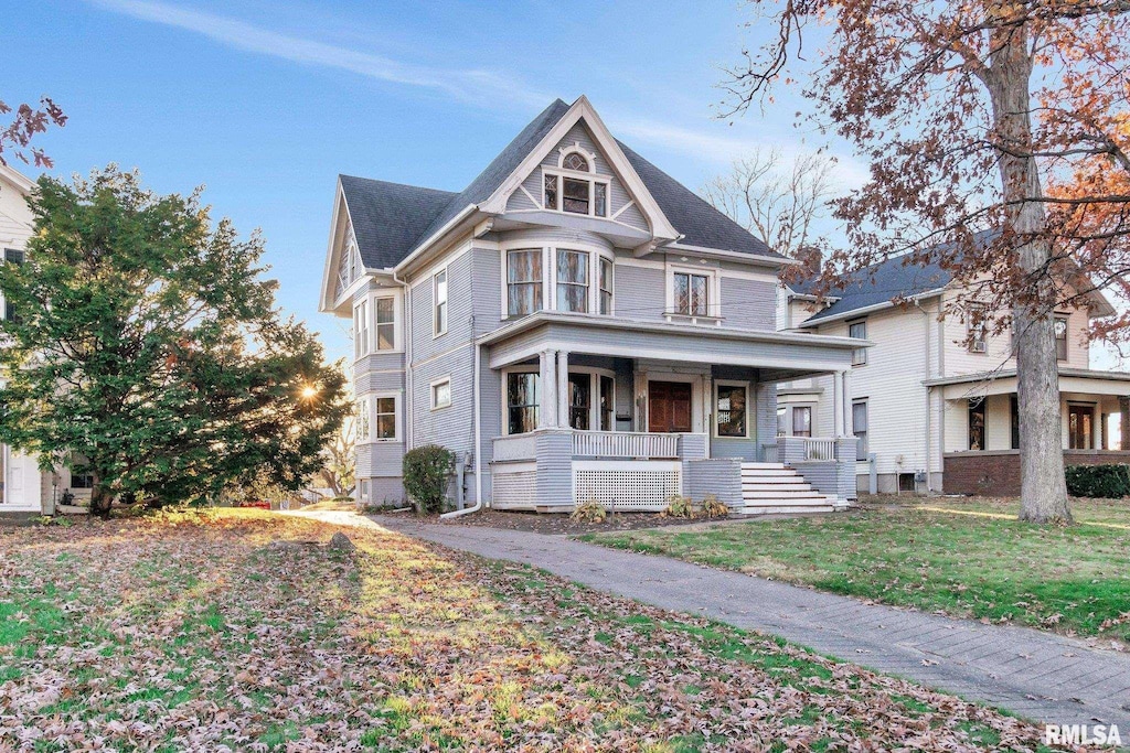 victorian home with a front yard and covered porch